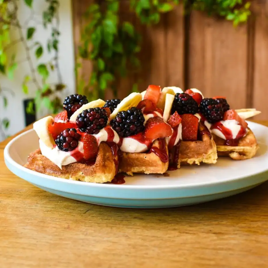 Waffles con moras, fresas, banano y crema